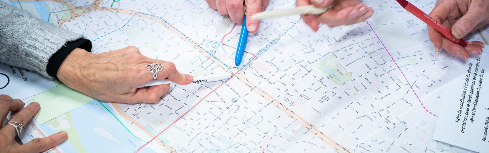 des mains qui pointent un point sur une carte