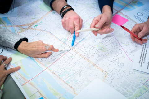 des mains qui pointent un point sur une carte