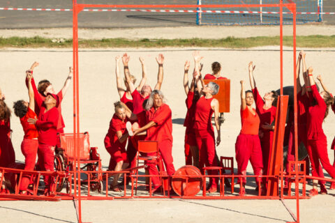 des artistes habillés en rouge sur scène en dansant
