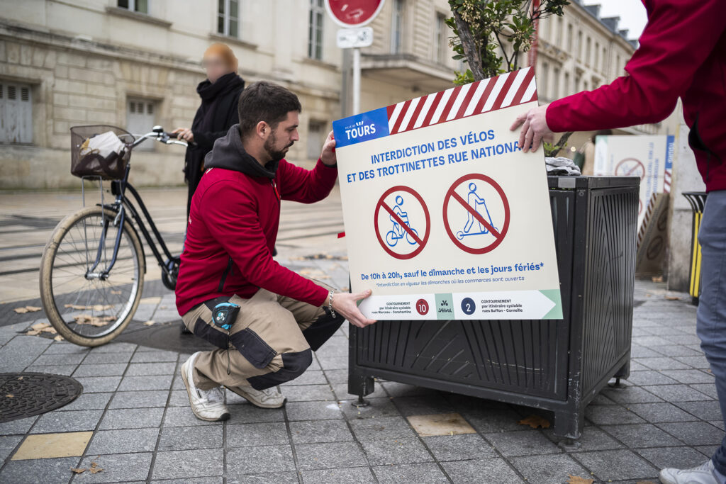 Agents de la ville qui installent les panneaux d'interdiction rue nationale - Agrandir l'image, fenêtre modale